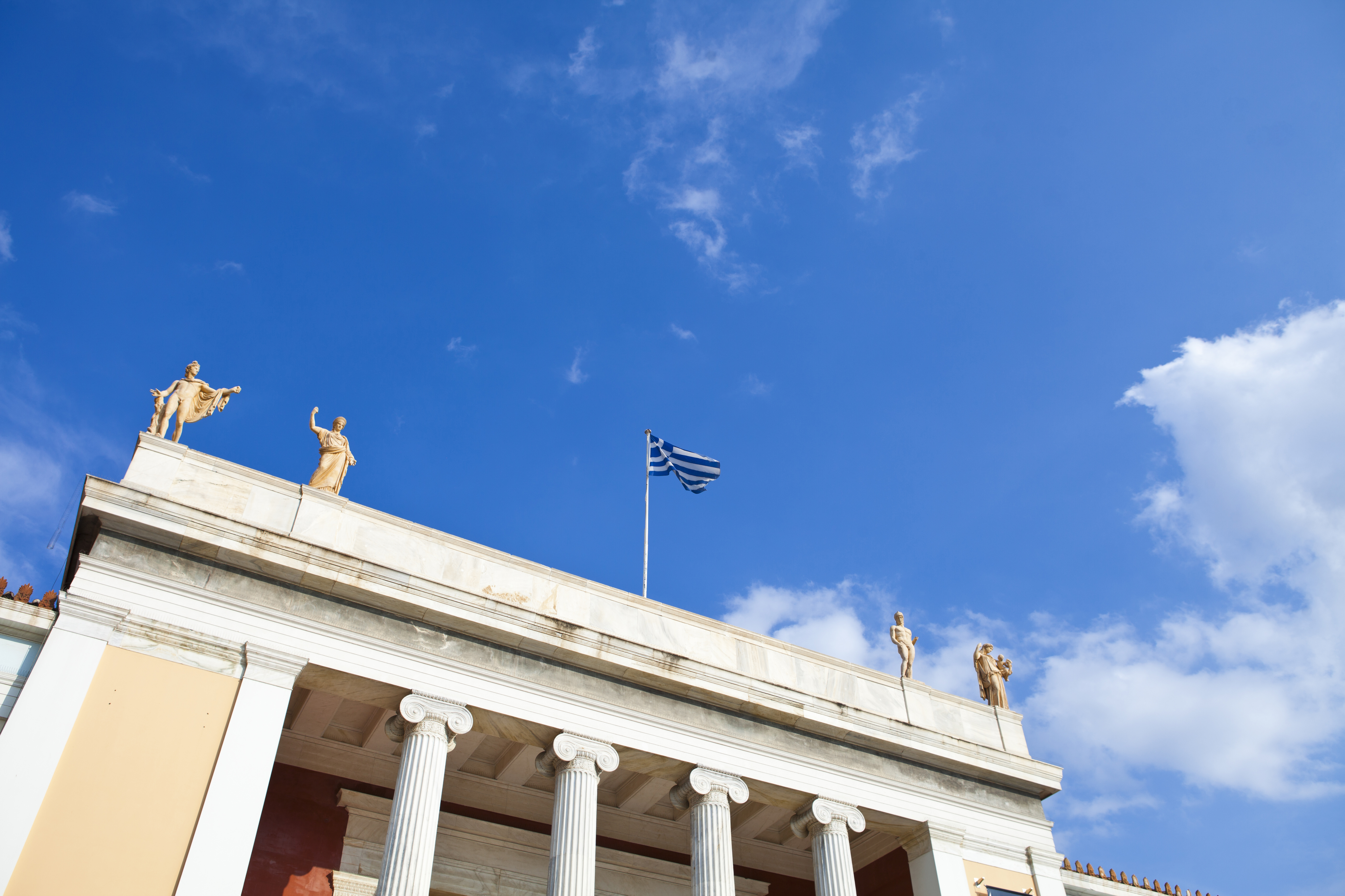 a building with columns and statues on top of it