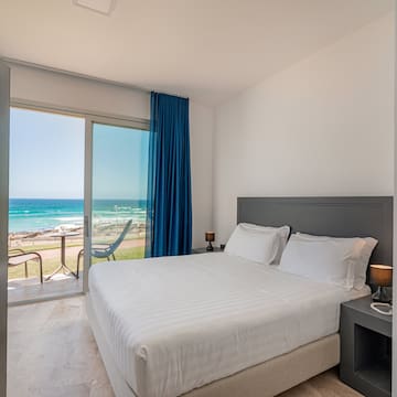 a bed with a glass door and a view of the ocean