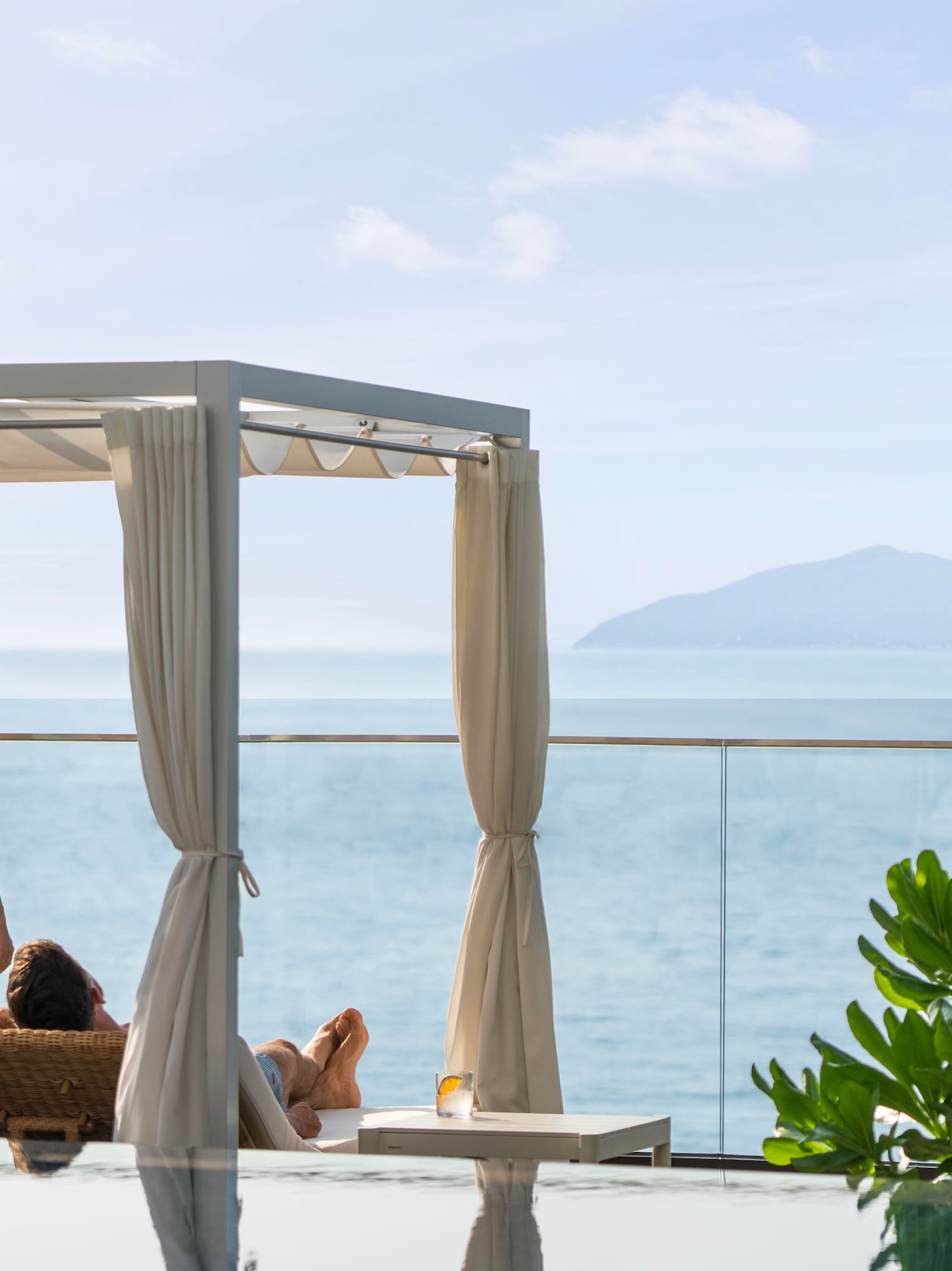 a woman in a swimsuit on a deck overlooking a body of water