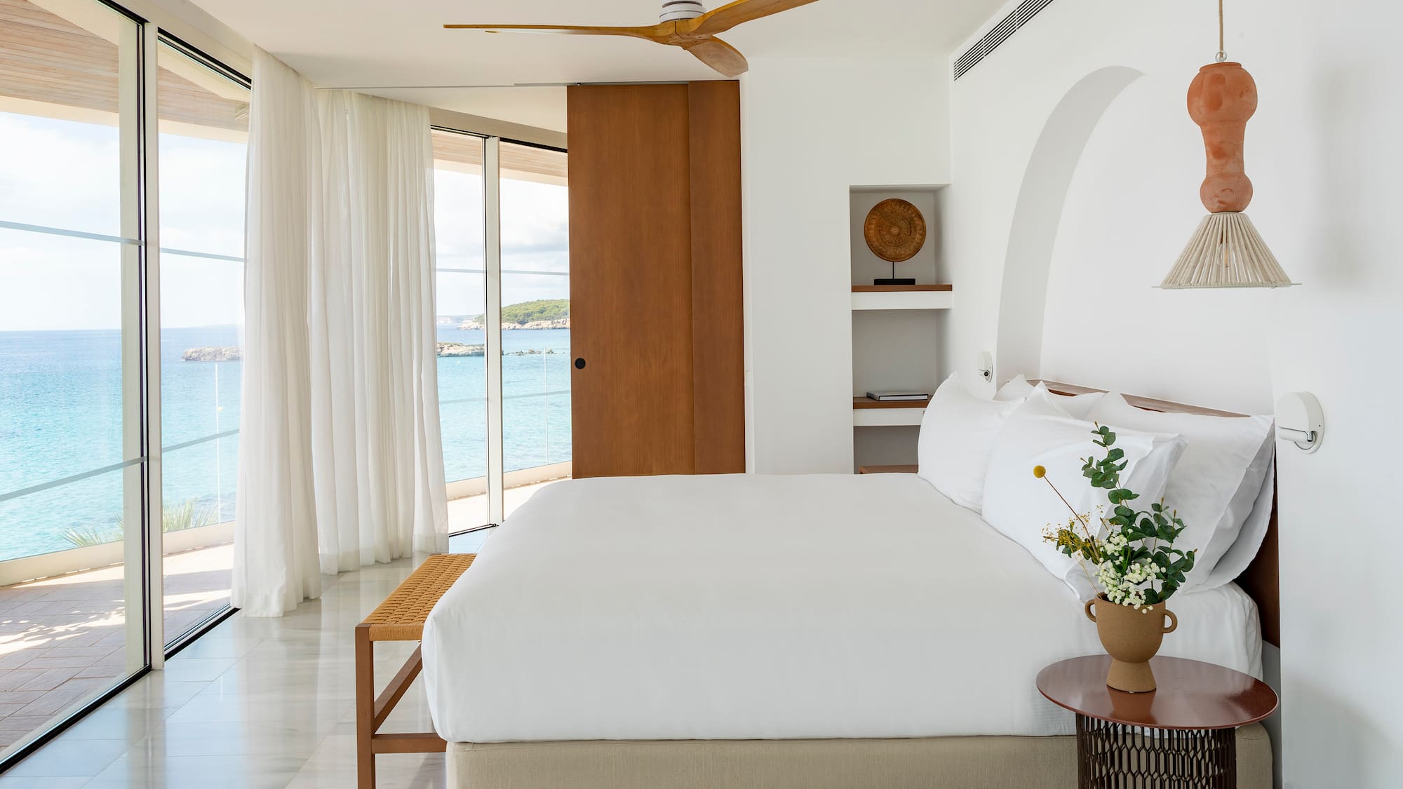 a bedroom with a large bed and a fan