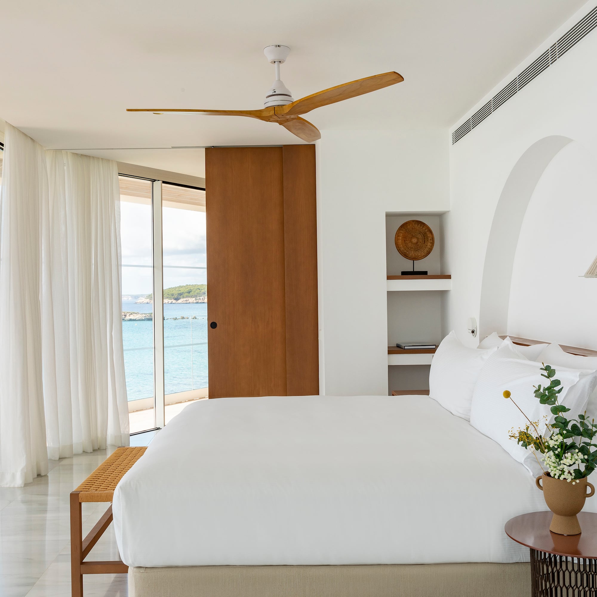a bedroom with a large bed and a fan