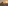 a wall with a building and a tower with a sunset