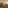 a wall with a building and a tower with a sunset