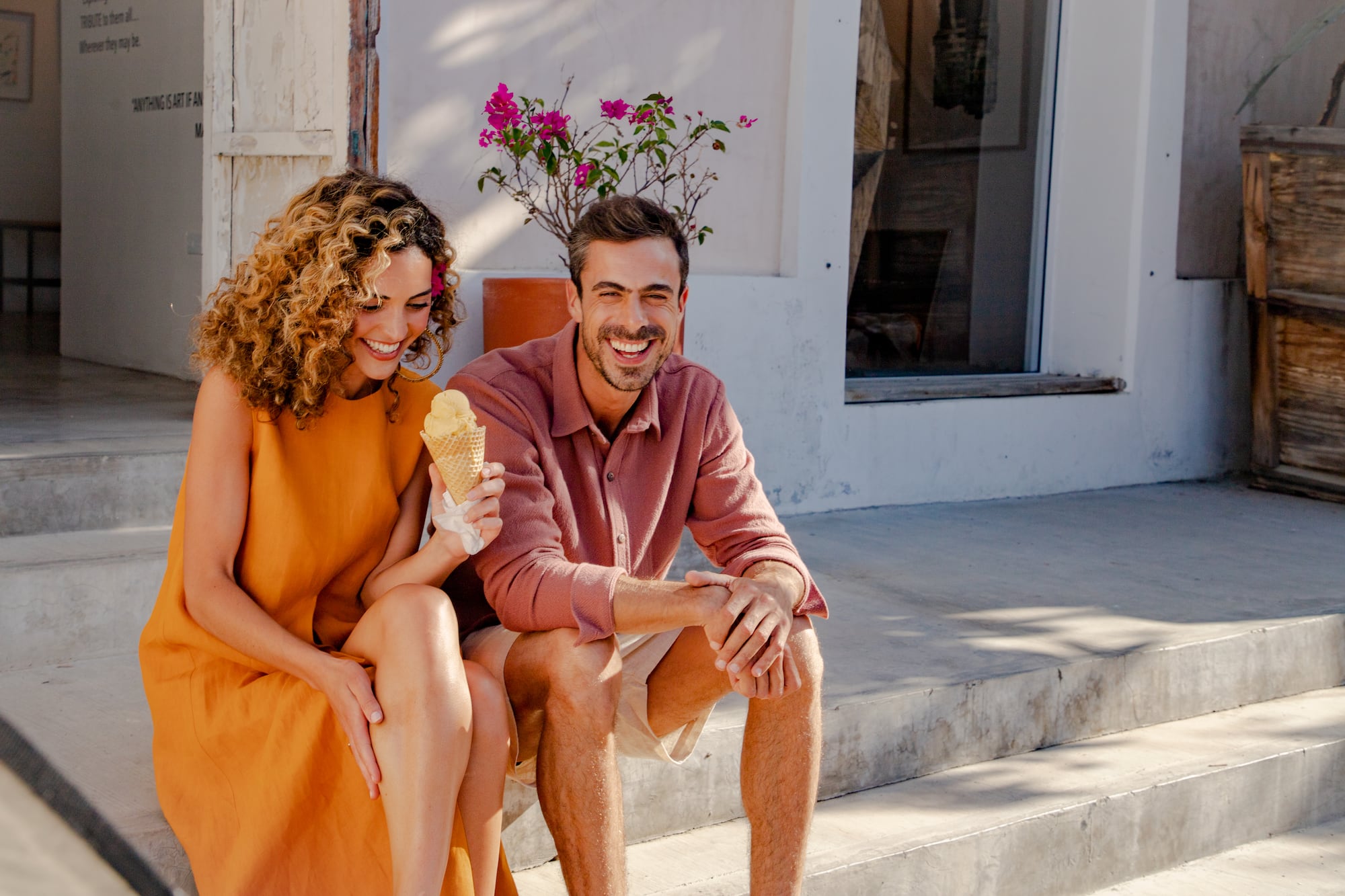 a man and woman sitting on stairs eating ice cream