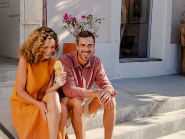 a man and woman sitting on stairs eating ice cream