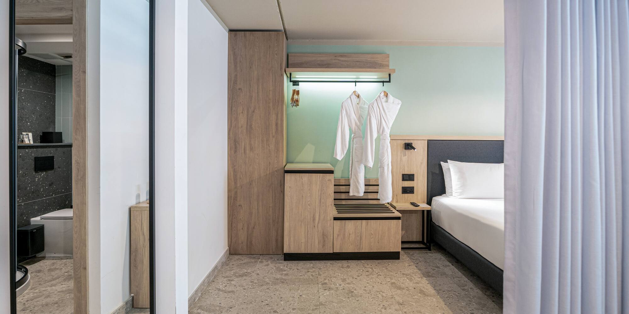 a room with a bed and white bathrobes