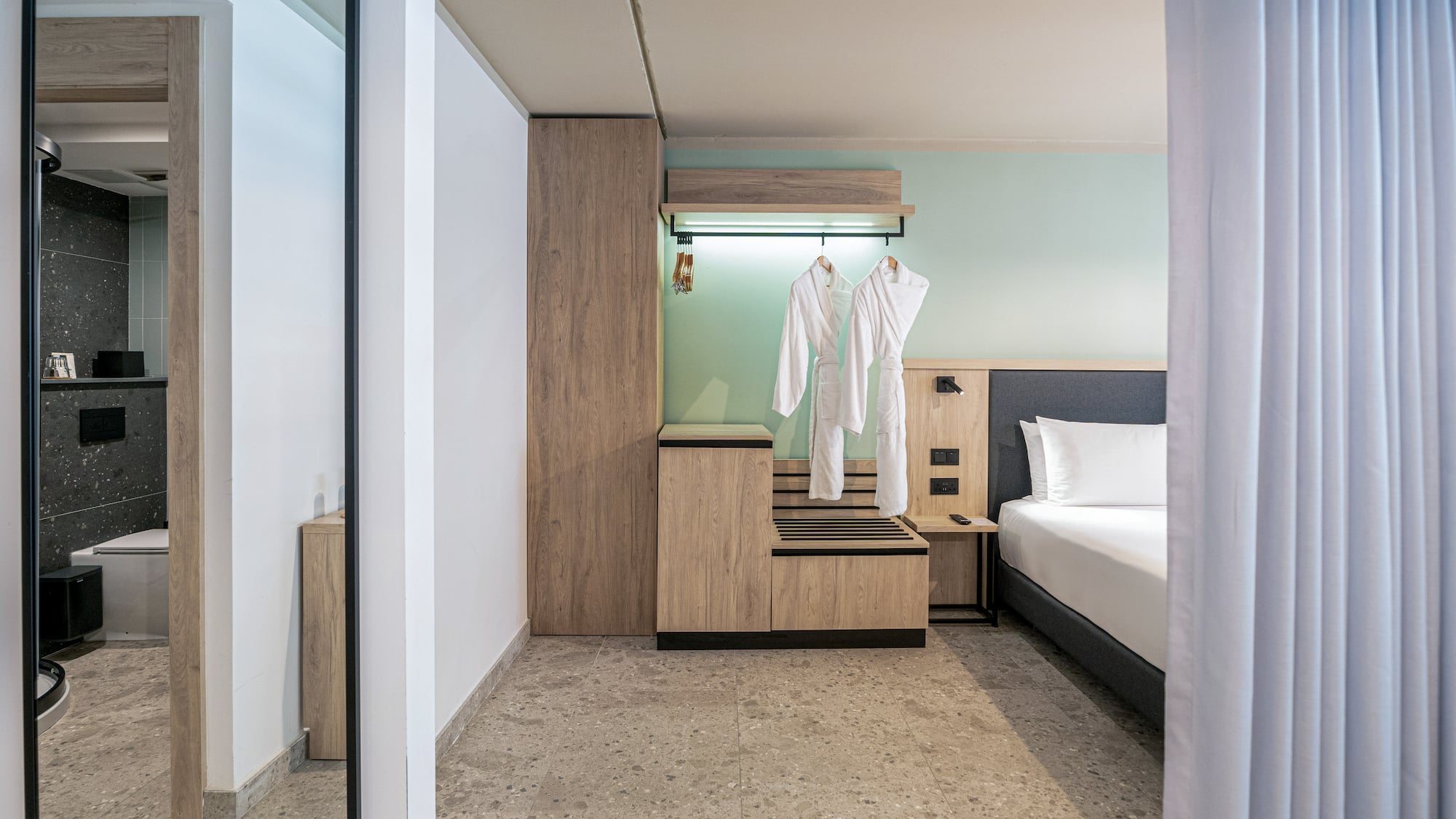 a room with a bed and white bathrobes