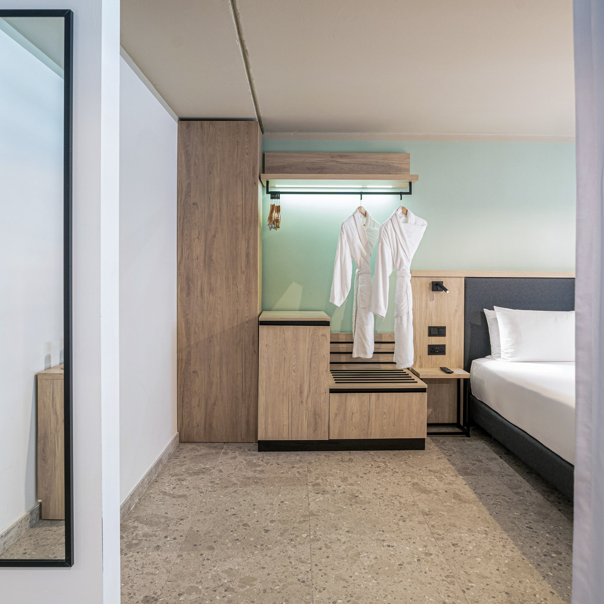 a room with a bed and white bathrobes