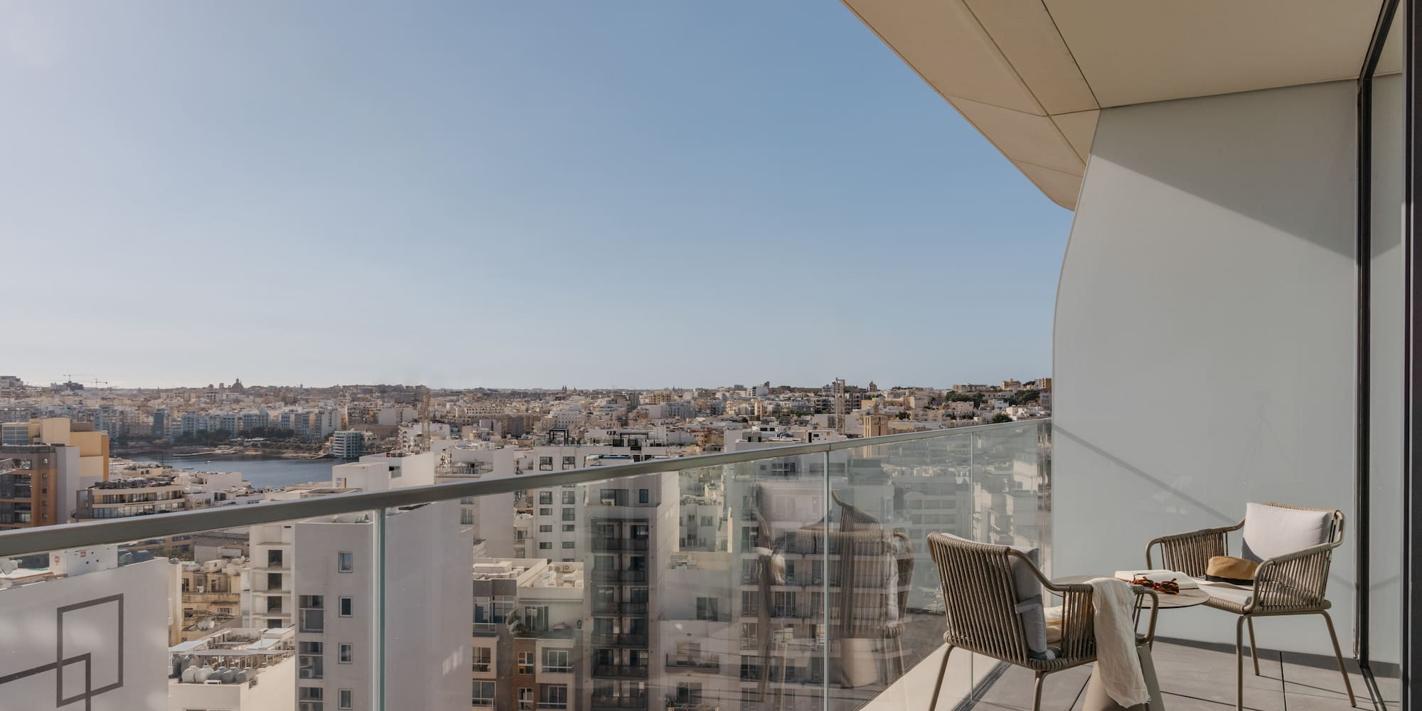a chair and table on a balcony overlooking a city