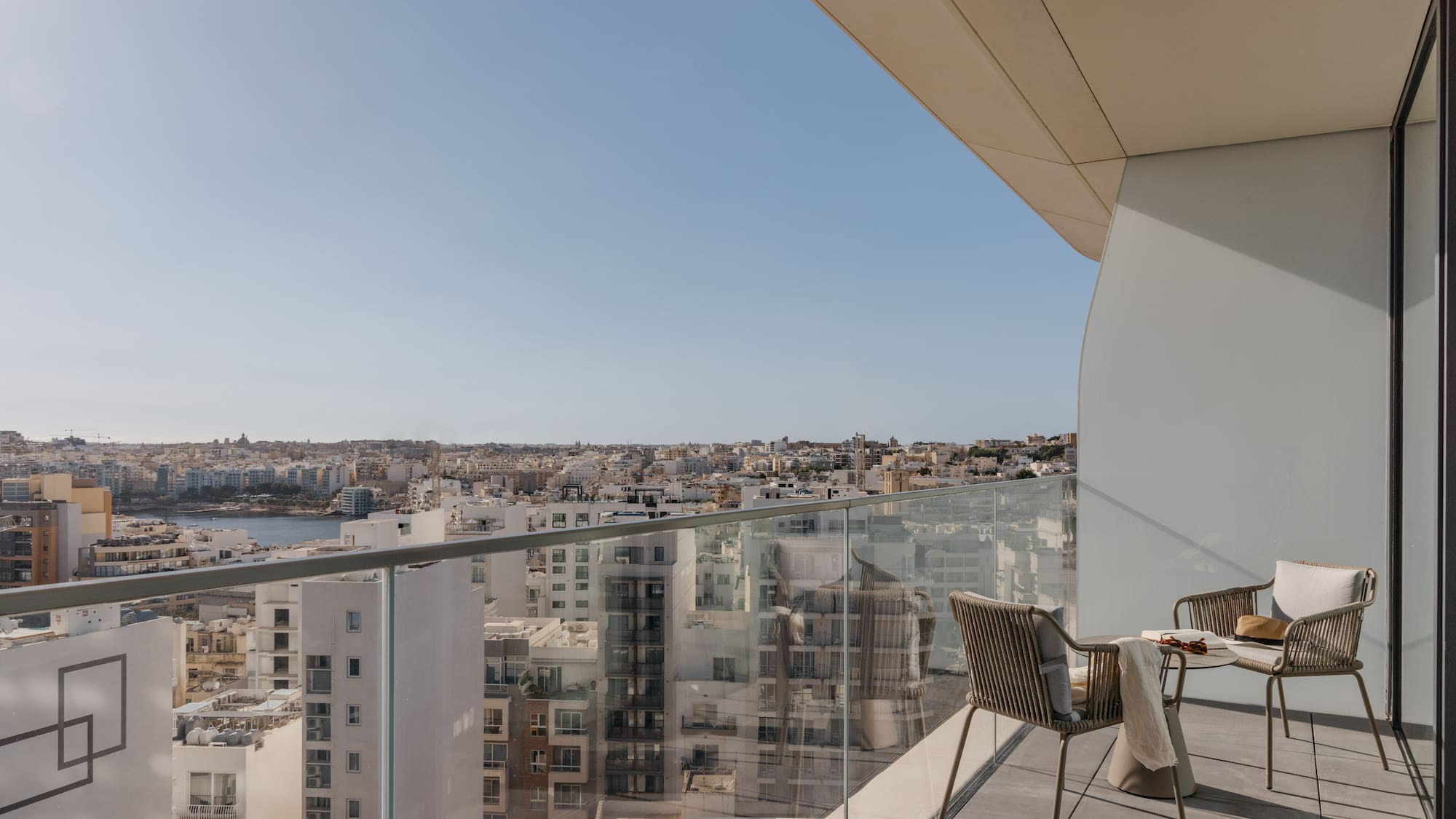 a chair and table on a balcony overlooking a city