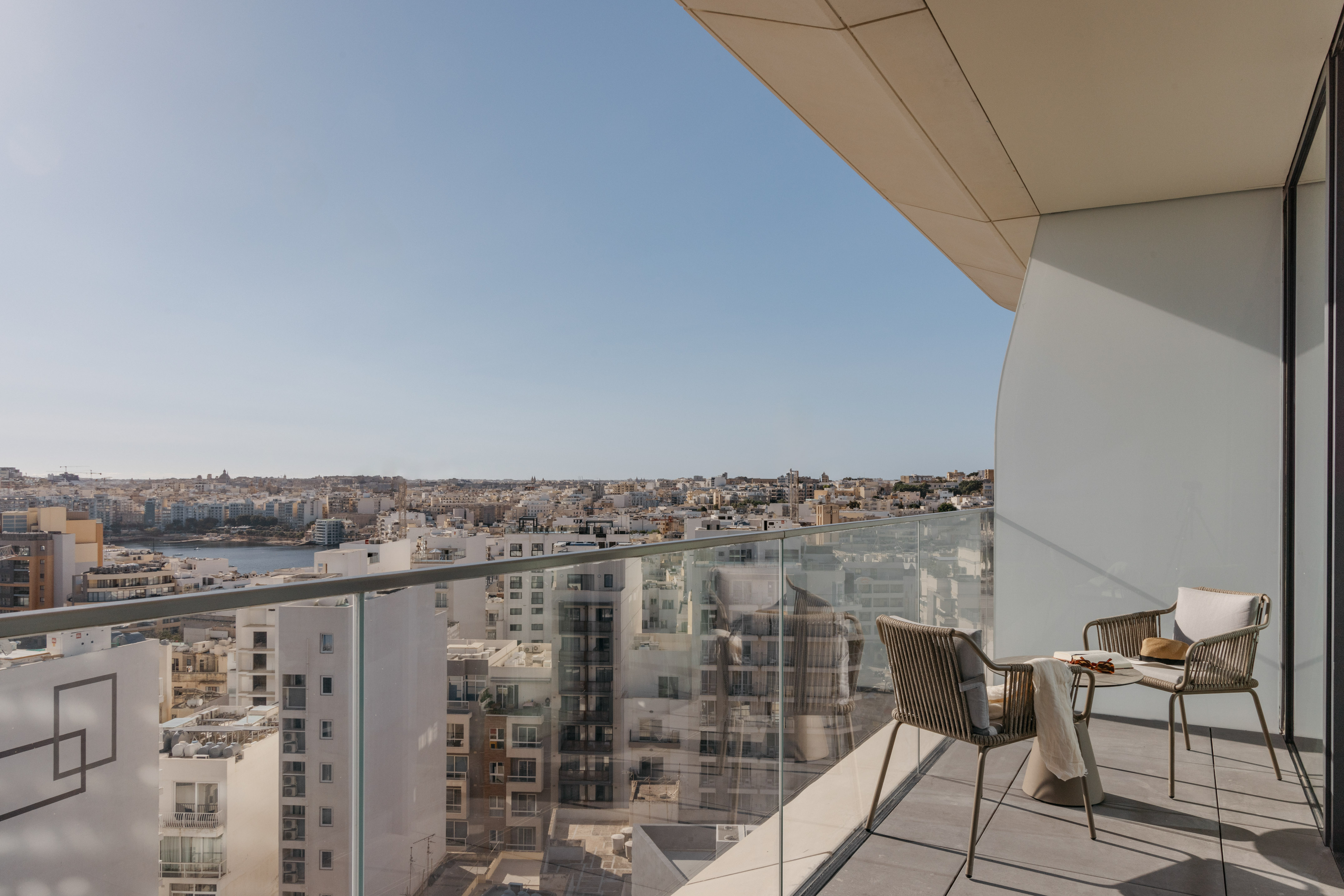 a chair and table on a balcony overlooking a city