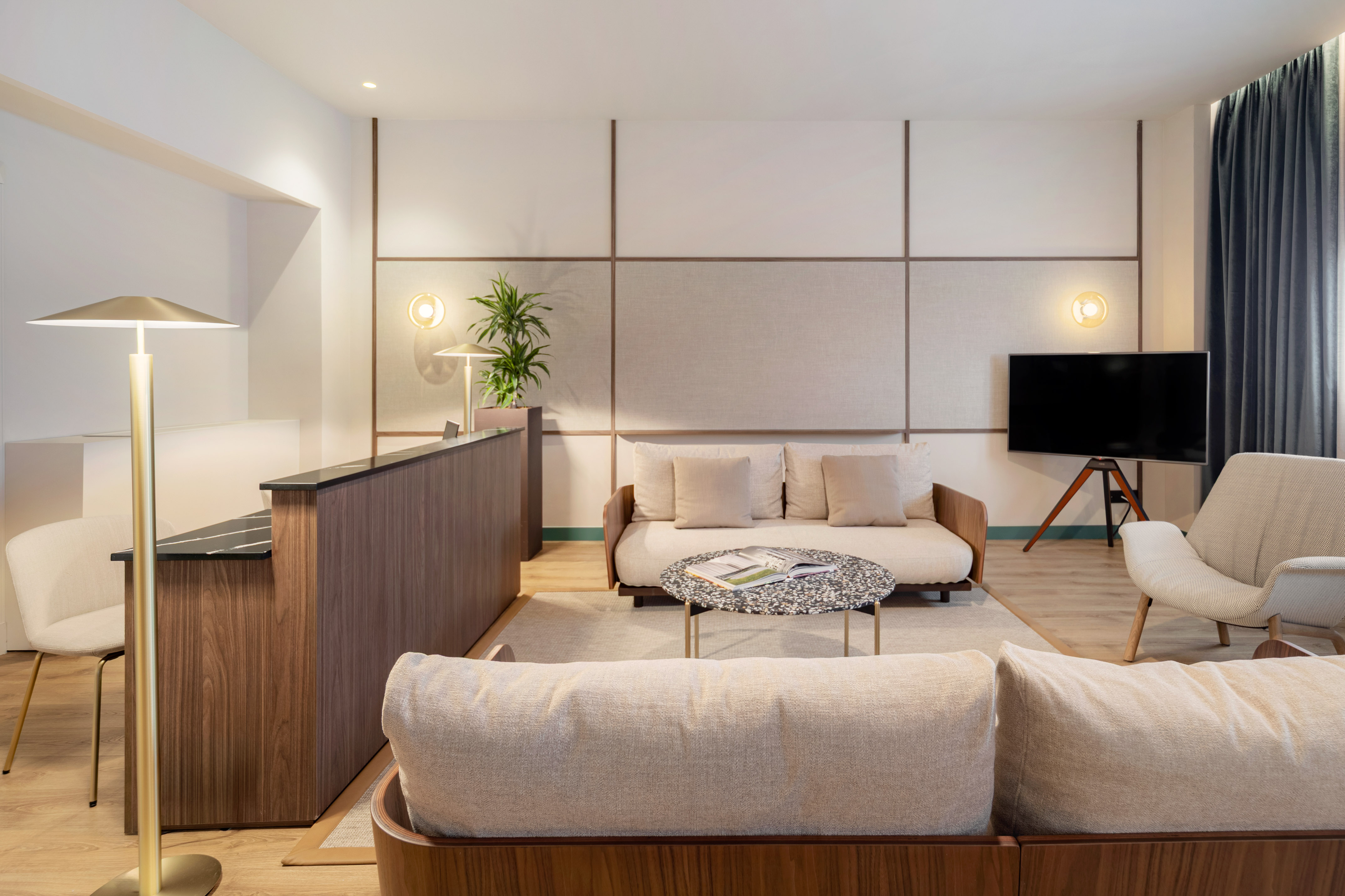 Modern hotel lobby interior with wood reception, sofas, and textured walls.