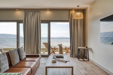 a living room with a view of the ocean and a couch