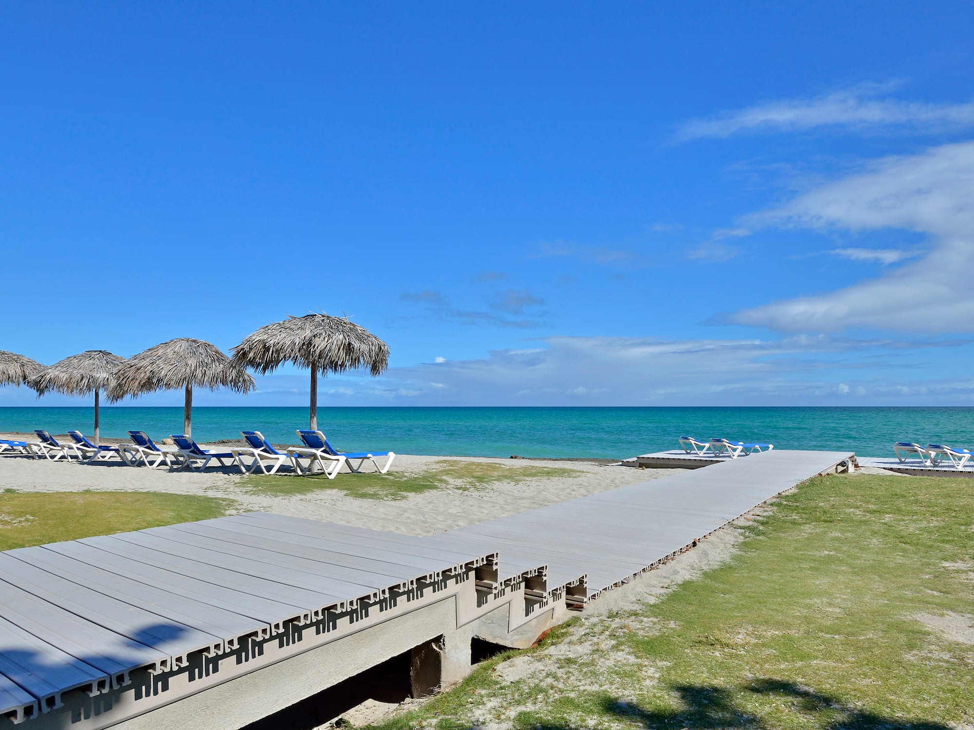 a beach with chairs and umbrellas
