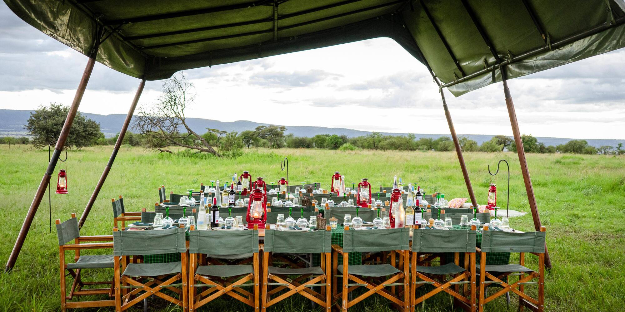 a table set up for a dinner party under a tent