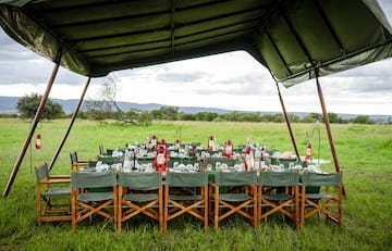 a table set up for a dinner party under a tent