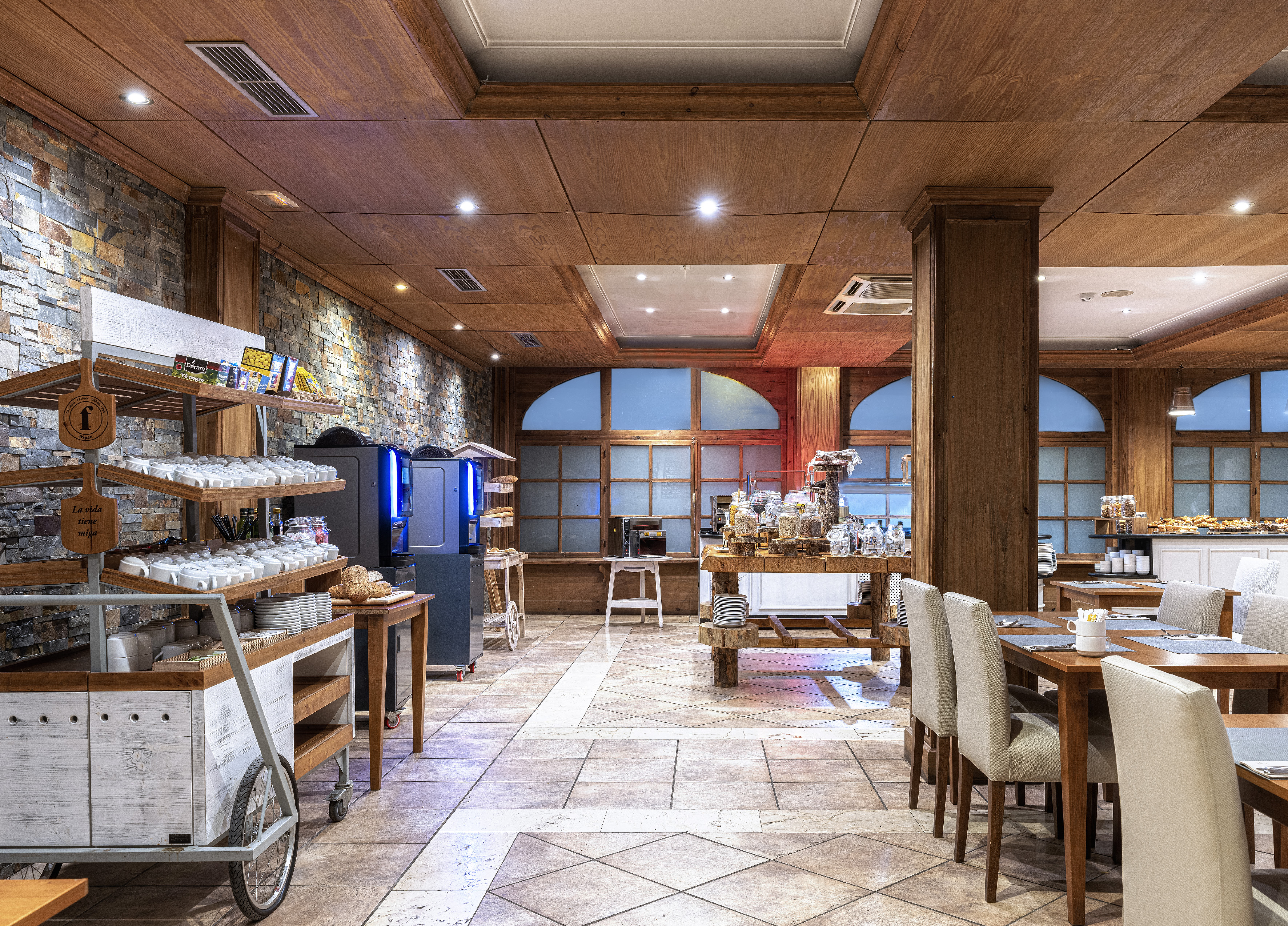 Hotel breakfast buffet dining room with wood interior and stone wall accents.