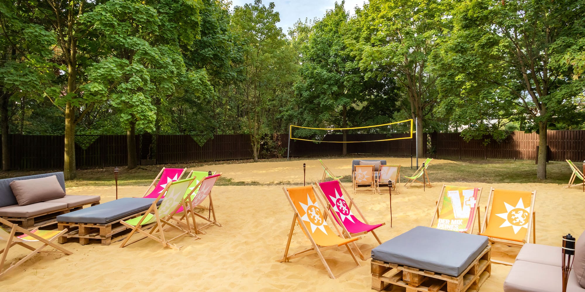 a beach chairs and volleyball net in a sandy area