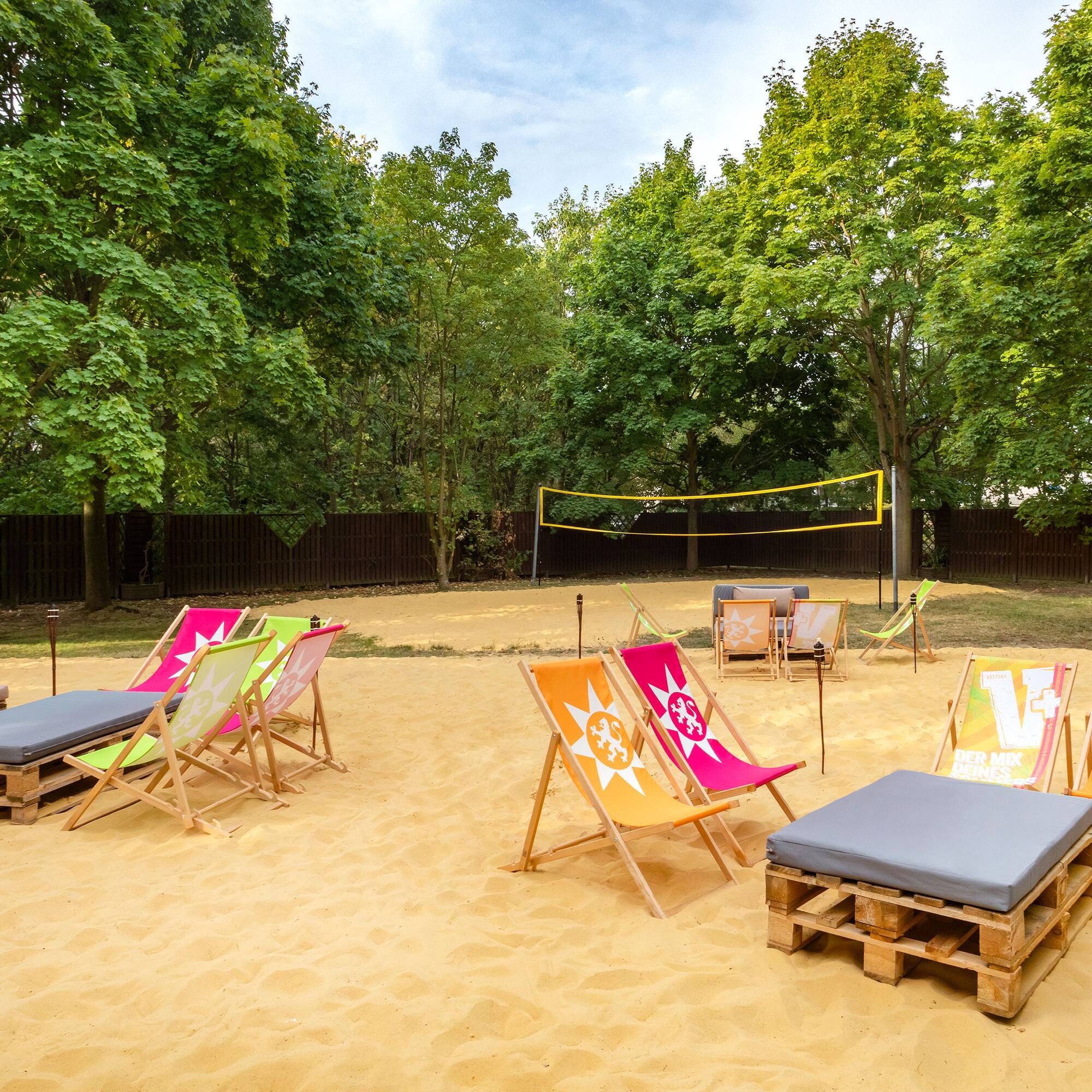 a beach chairs and volleyball net in a sandy area
