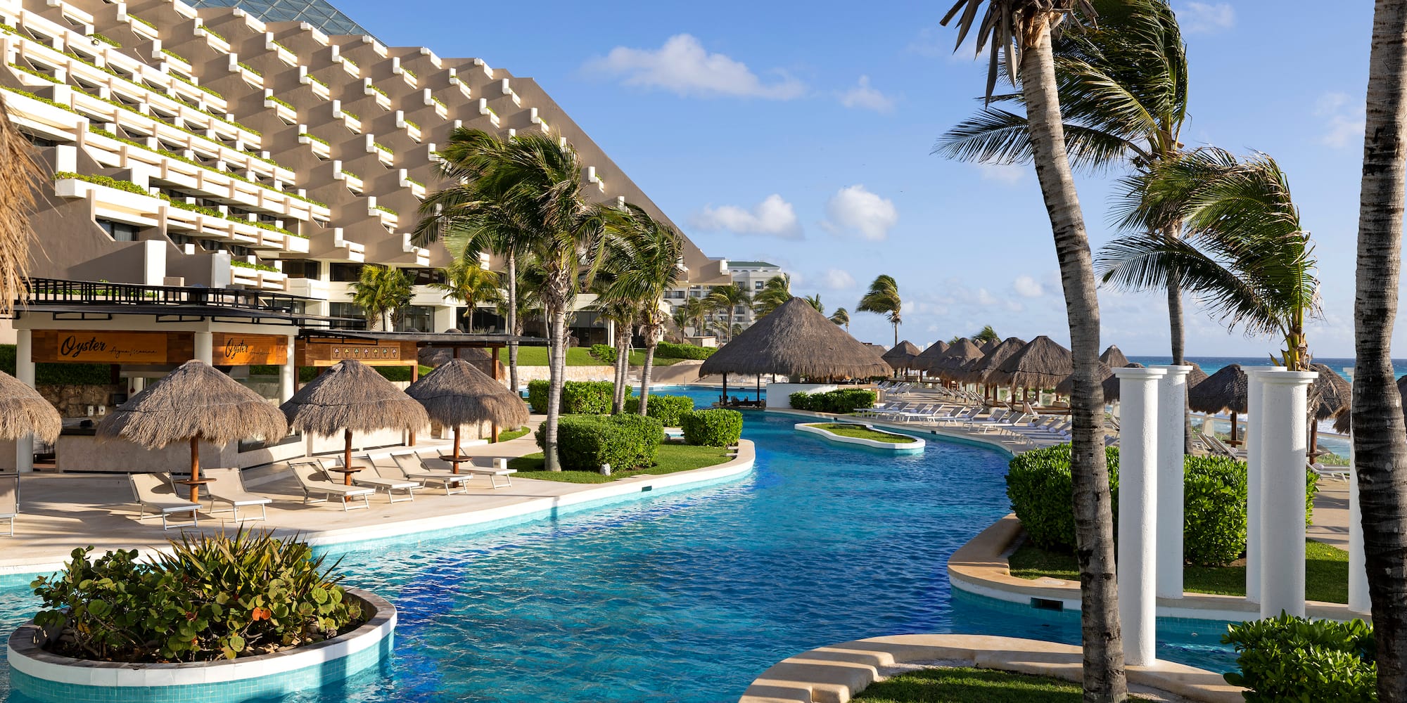 a pool with palm trees and a building