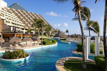 a pool with palm trees and a building