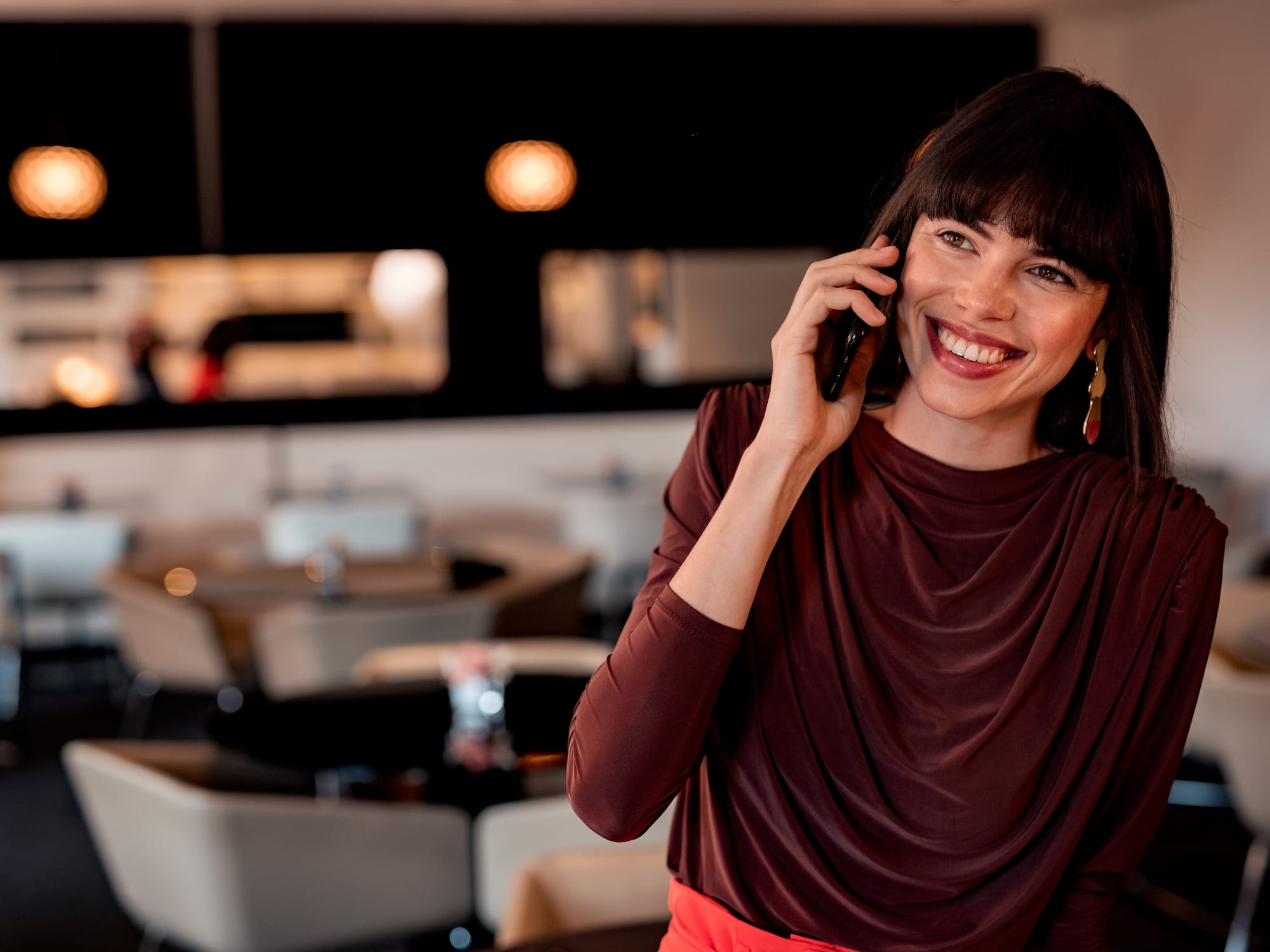 a woman smiling while talking on a cell phone