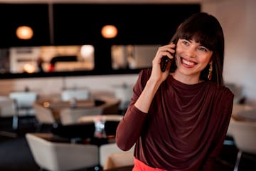 a woman smiling while talking on a cell phone