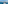 White sailing catamaran with paddleboards on blue sea by coastal town.