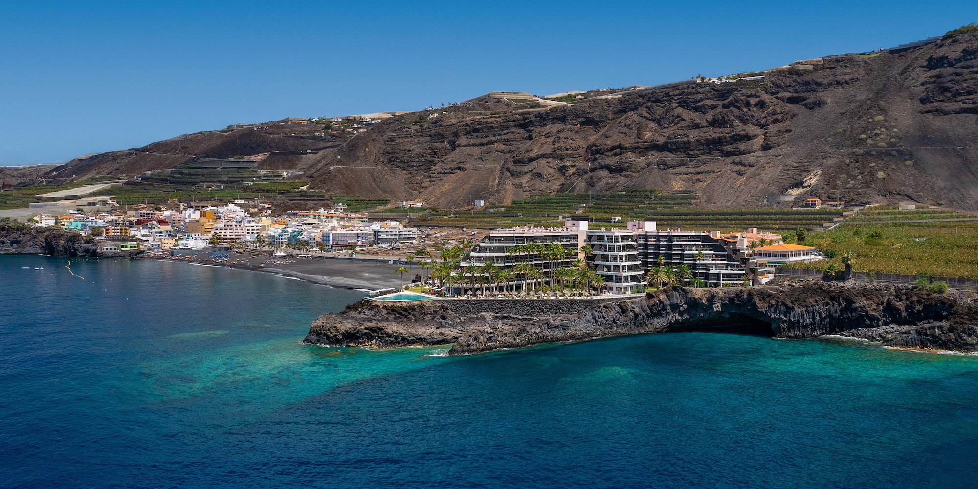 a building on a cliff above water.