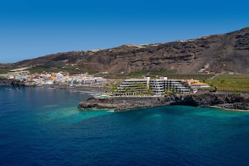 a building on a cliff above water.
