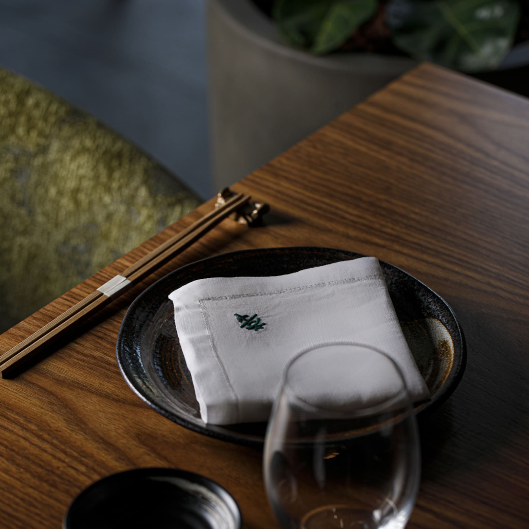 a plate with a napkin and chopsticks on a table