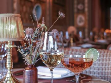 a table with wine glasses and a vase of flowers