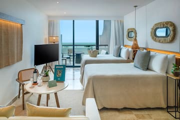 a room with two beds and a television