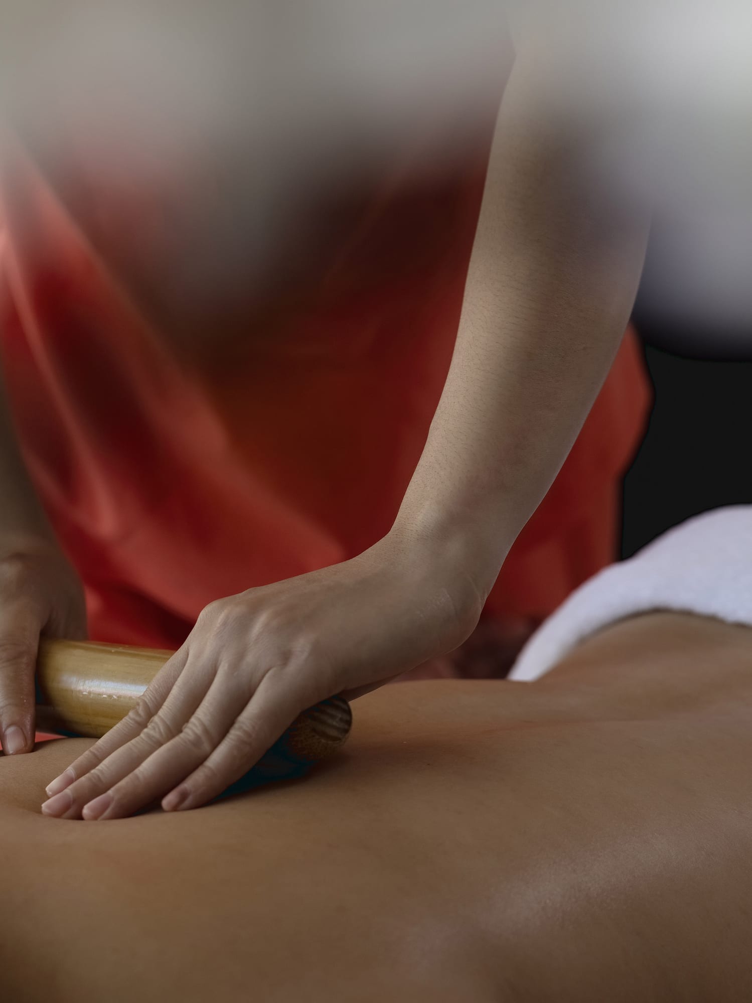 a person using a roller to massage a person's back