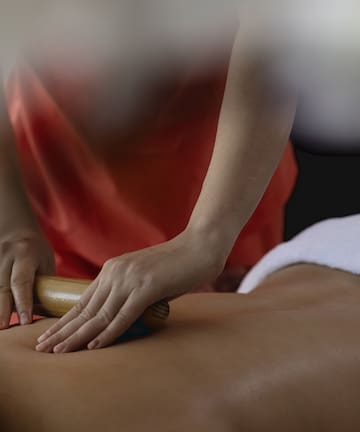 a person using a roller to massage a person's back