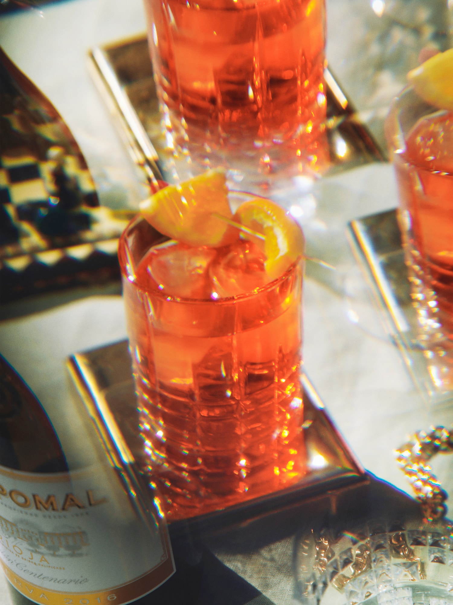 a group of glasses with orange liquid and a slice of lemon