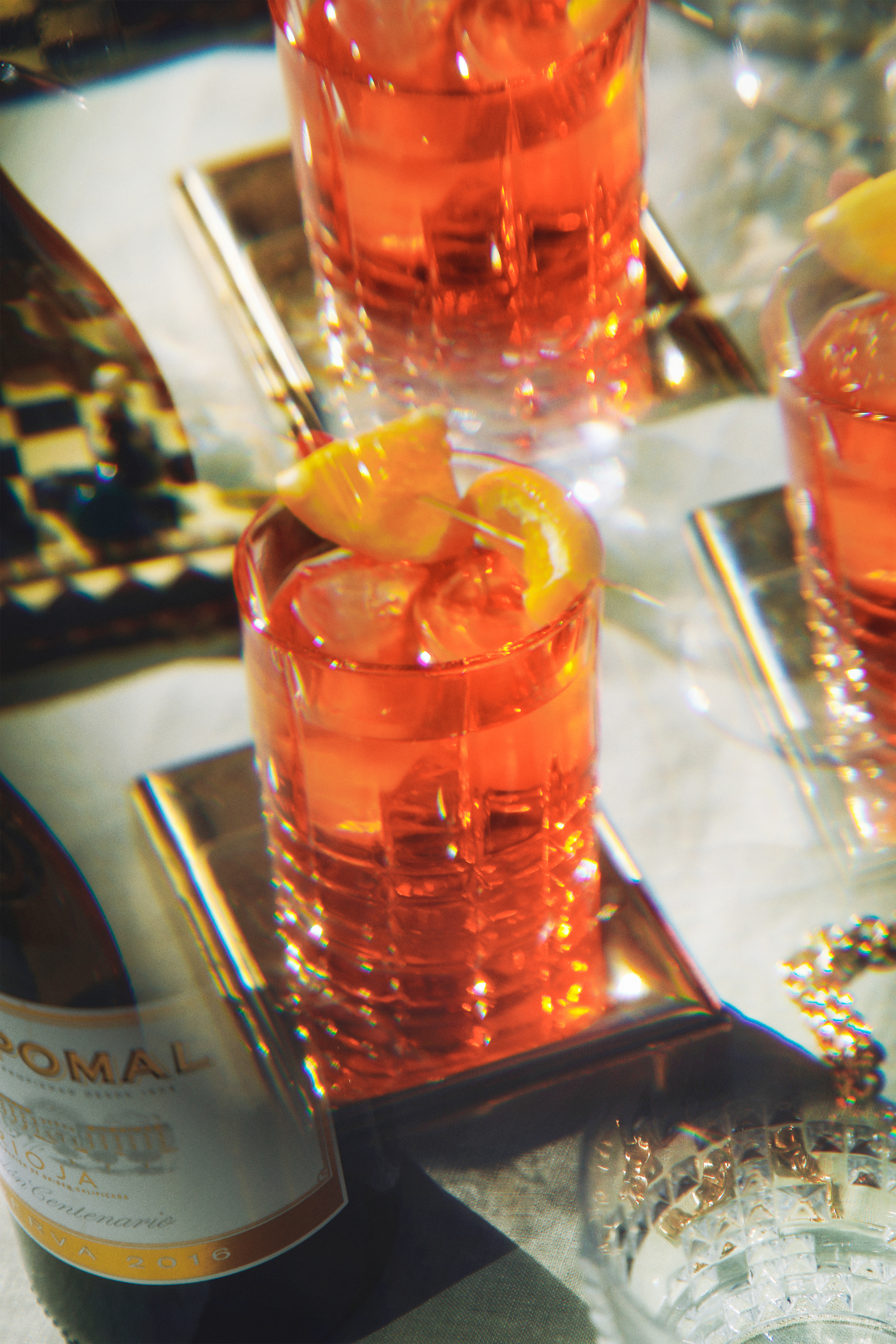 a group of glasses with orange liquid and a slice of lemon