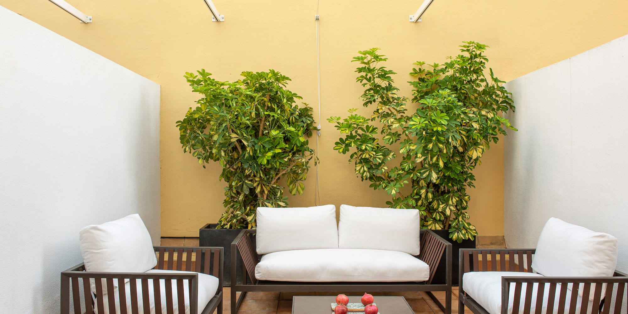 a patio with white couches and a table