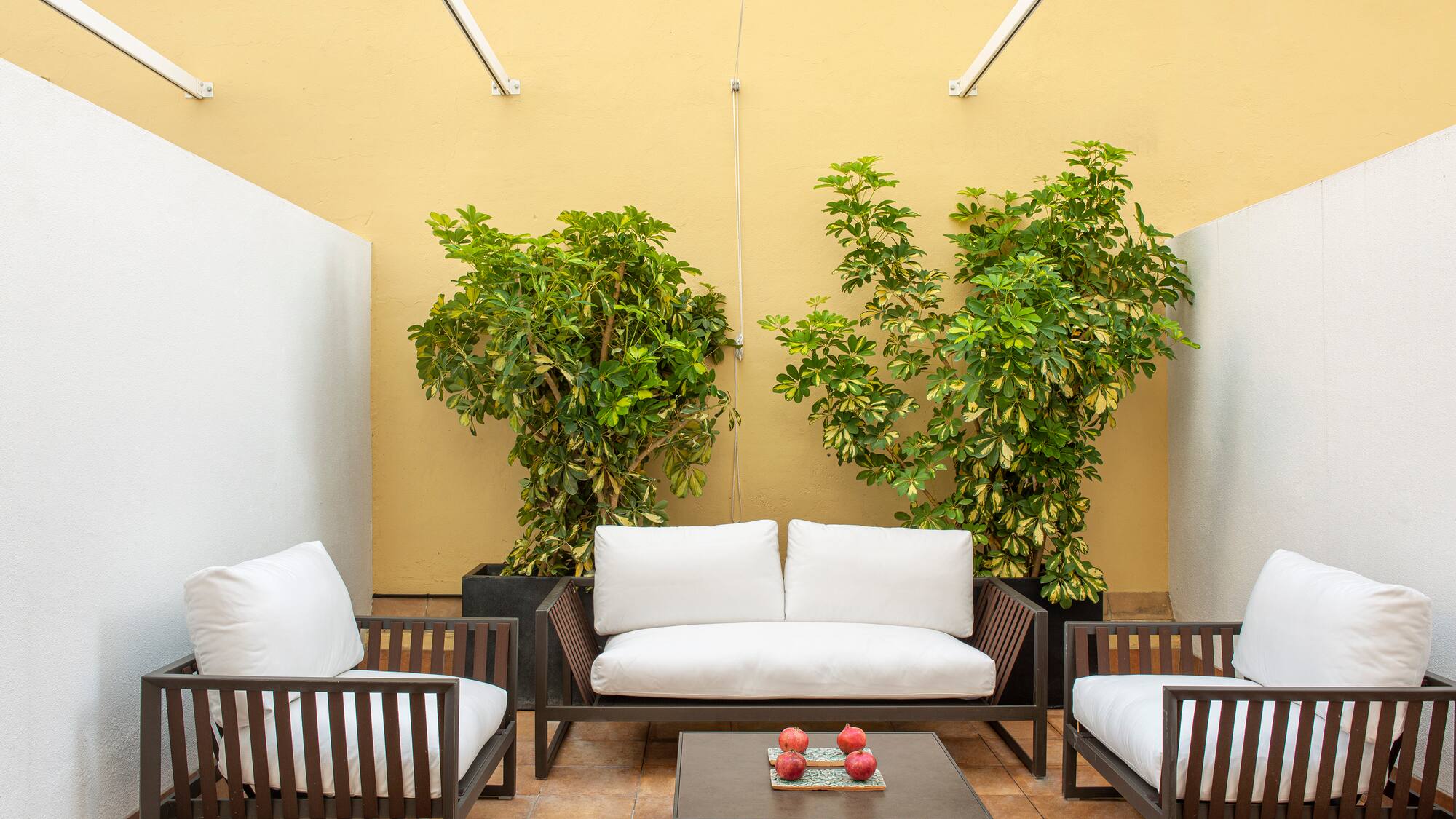 a patio with white couches and a table