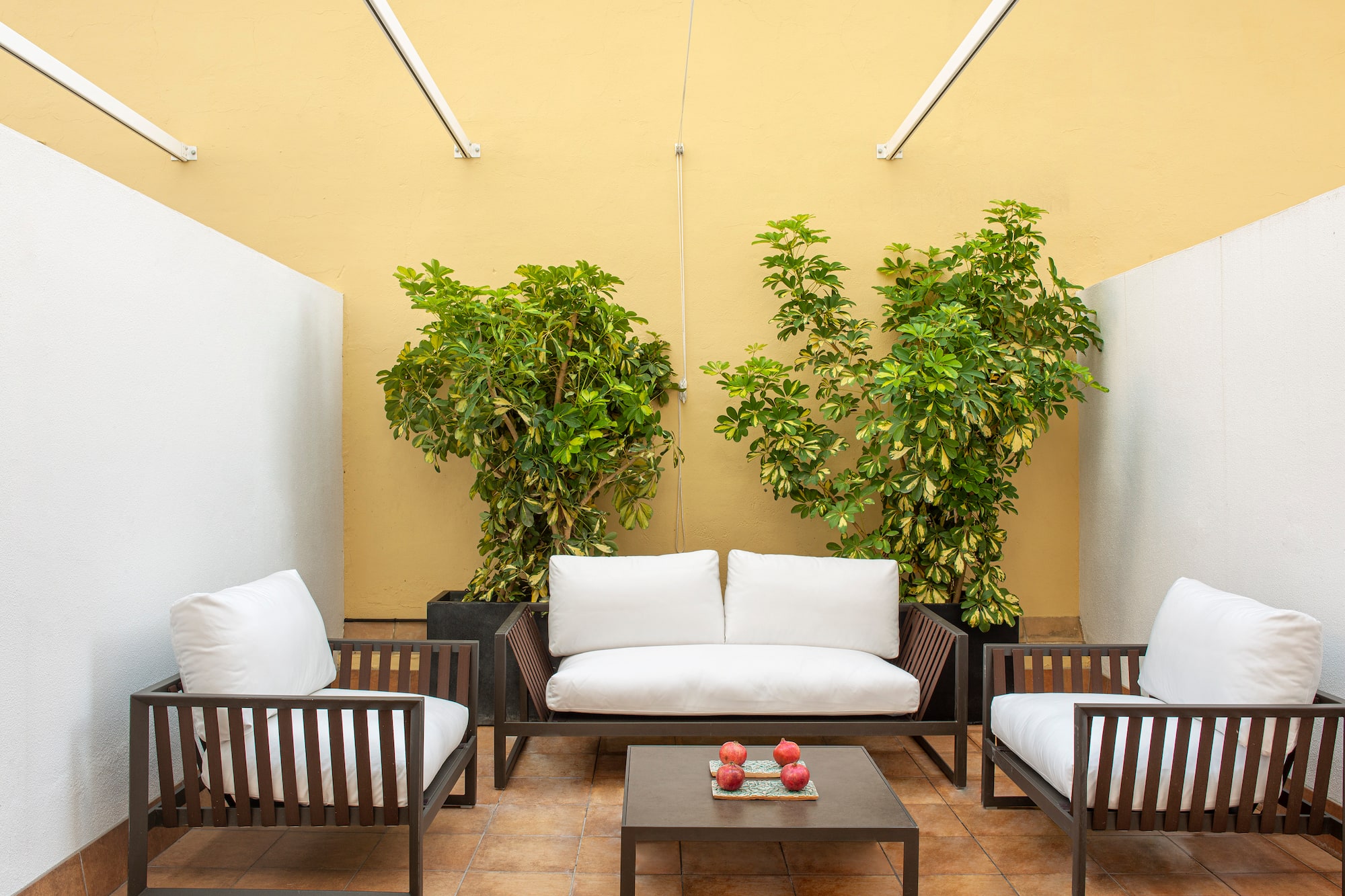 a patio with white couches and a table
