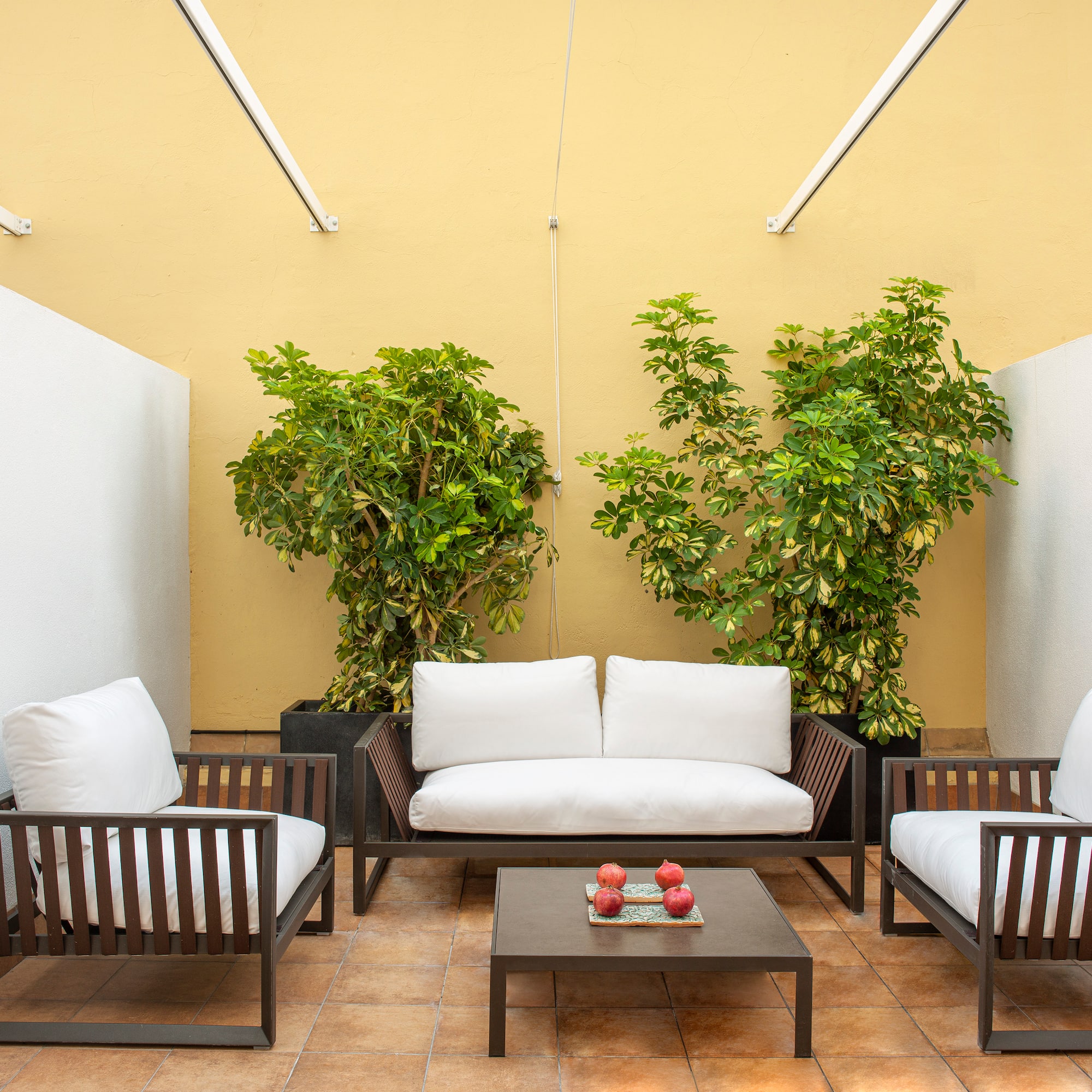 a patio with white couches and a table