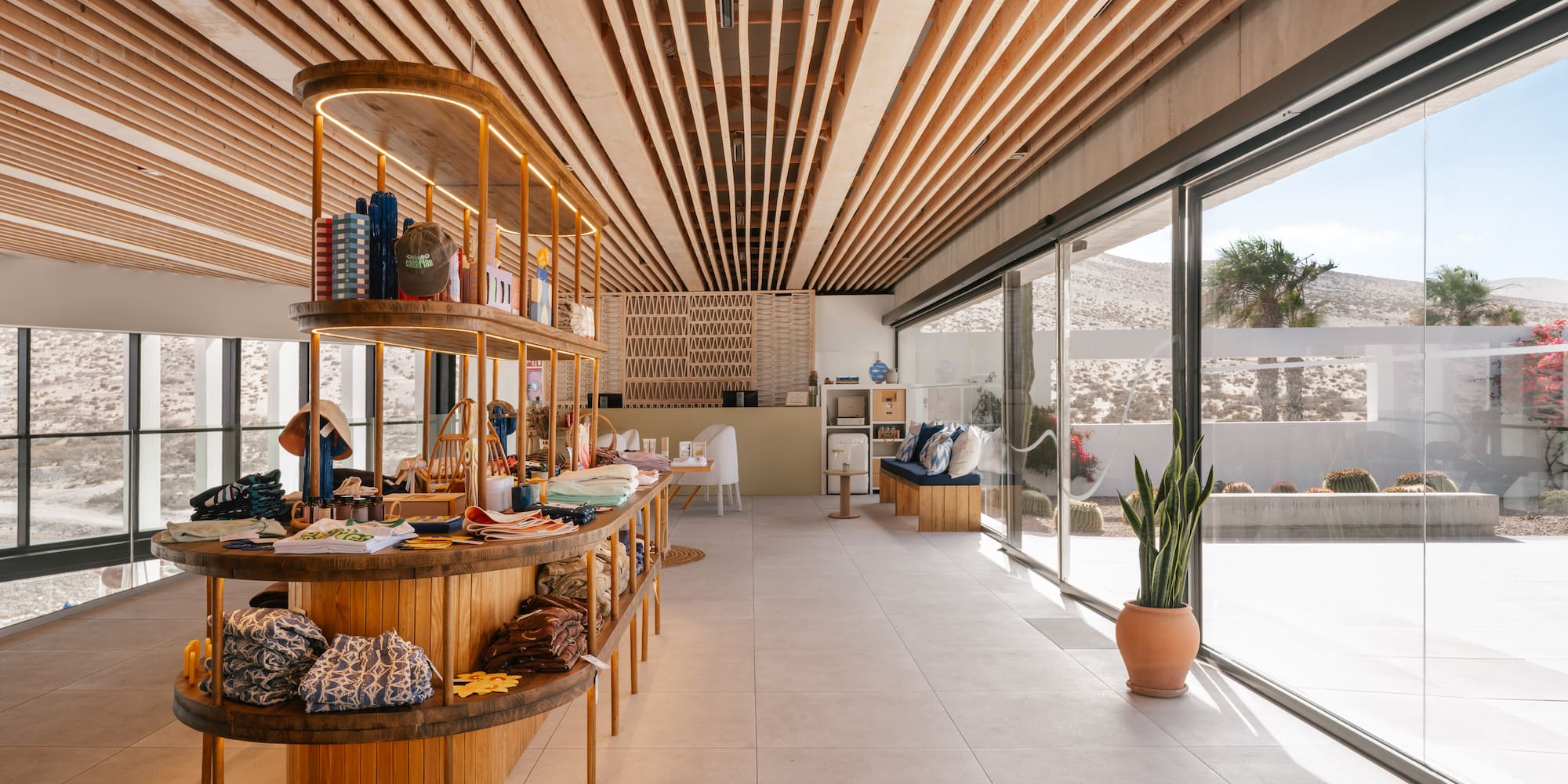 Stylish retail boutique with wooden shelving, slatted ceiling, and desert views.