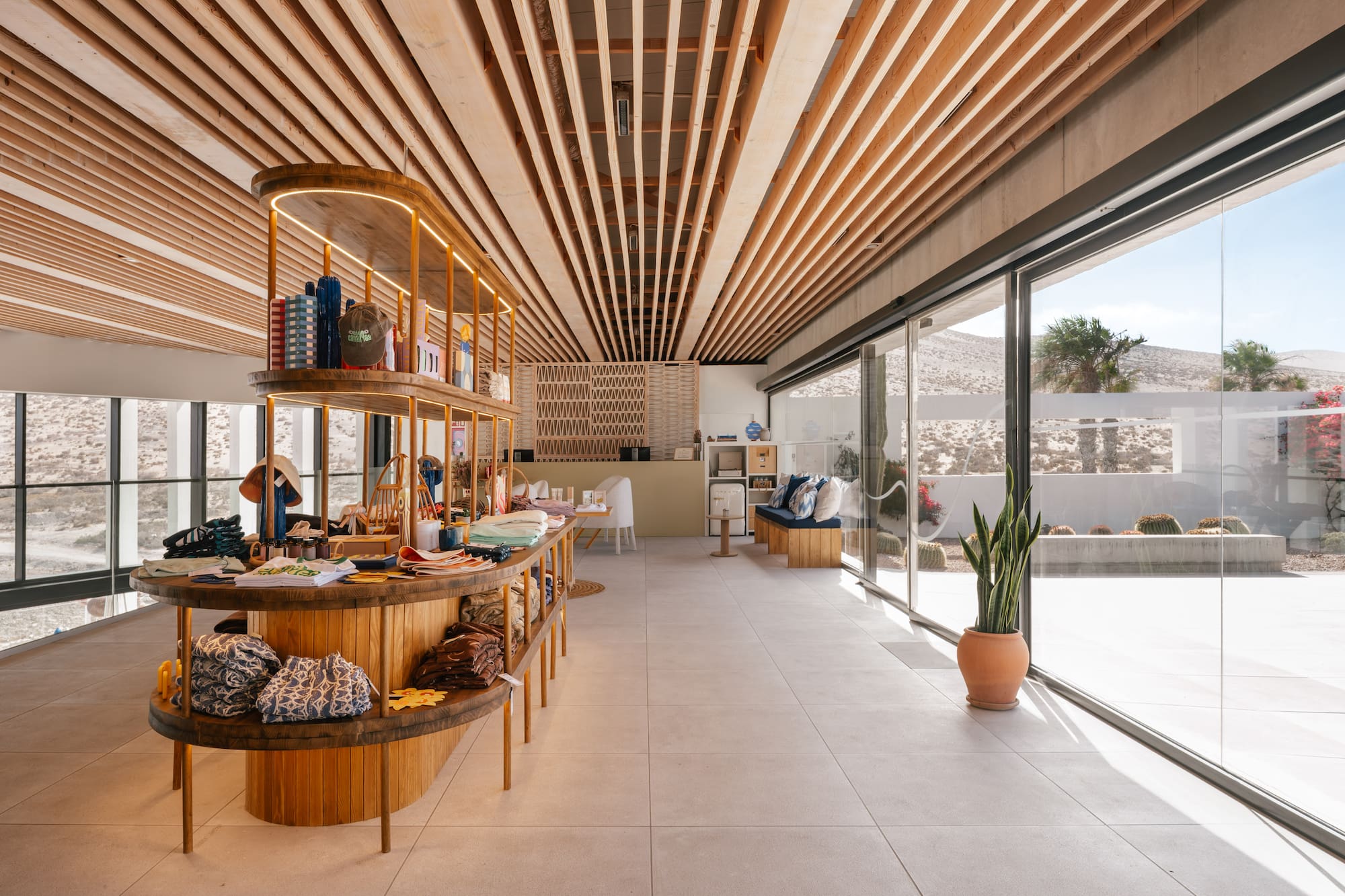 Stylish retail boutique with wooden shelving, slatted ceiling, and desert views.
