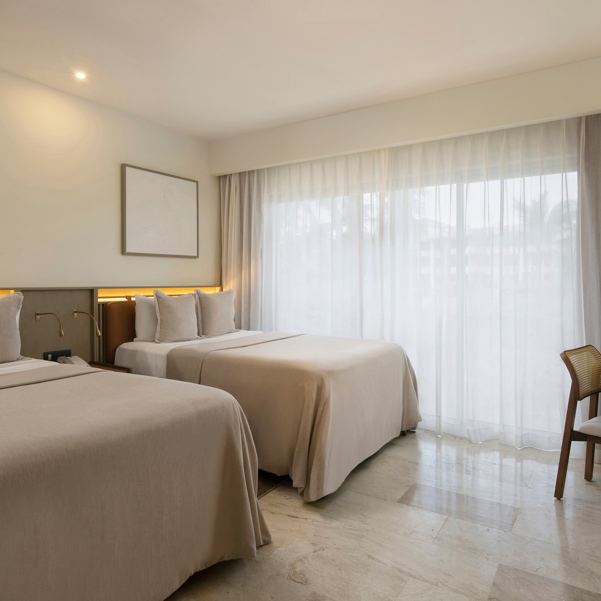 a room with two beds and a chair