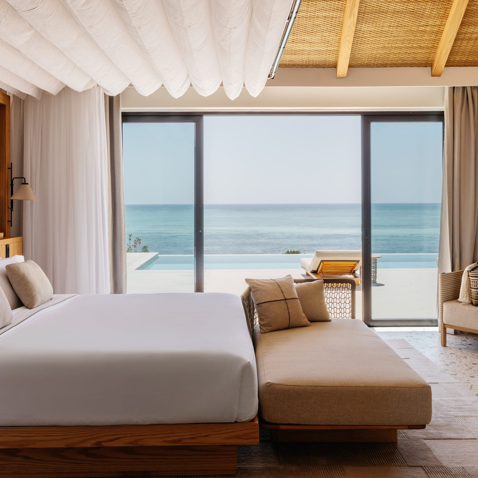 a bedroom with a large bed and a couch and a pool