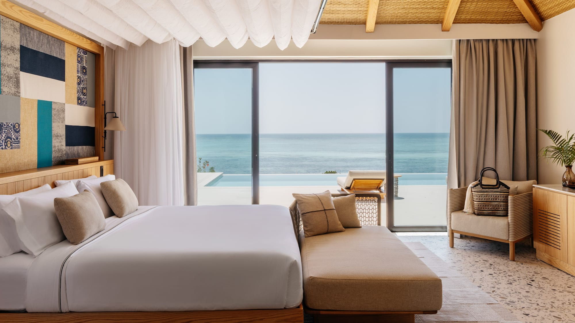 a bedroom with a large bed and a couch and a pool