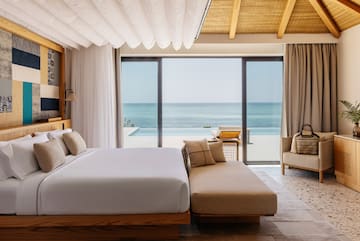 a bedroom with a large bed and a couch and a pool