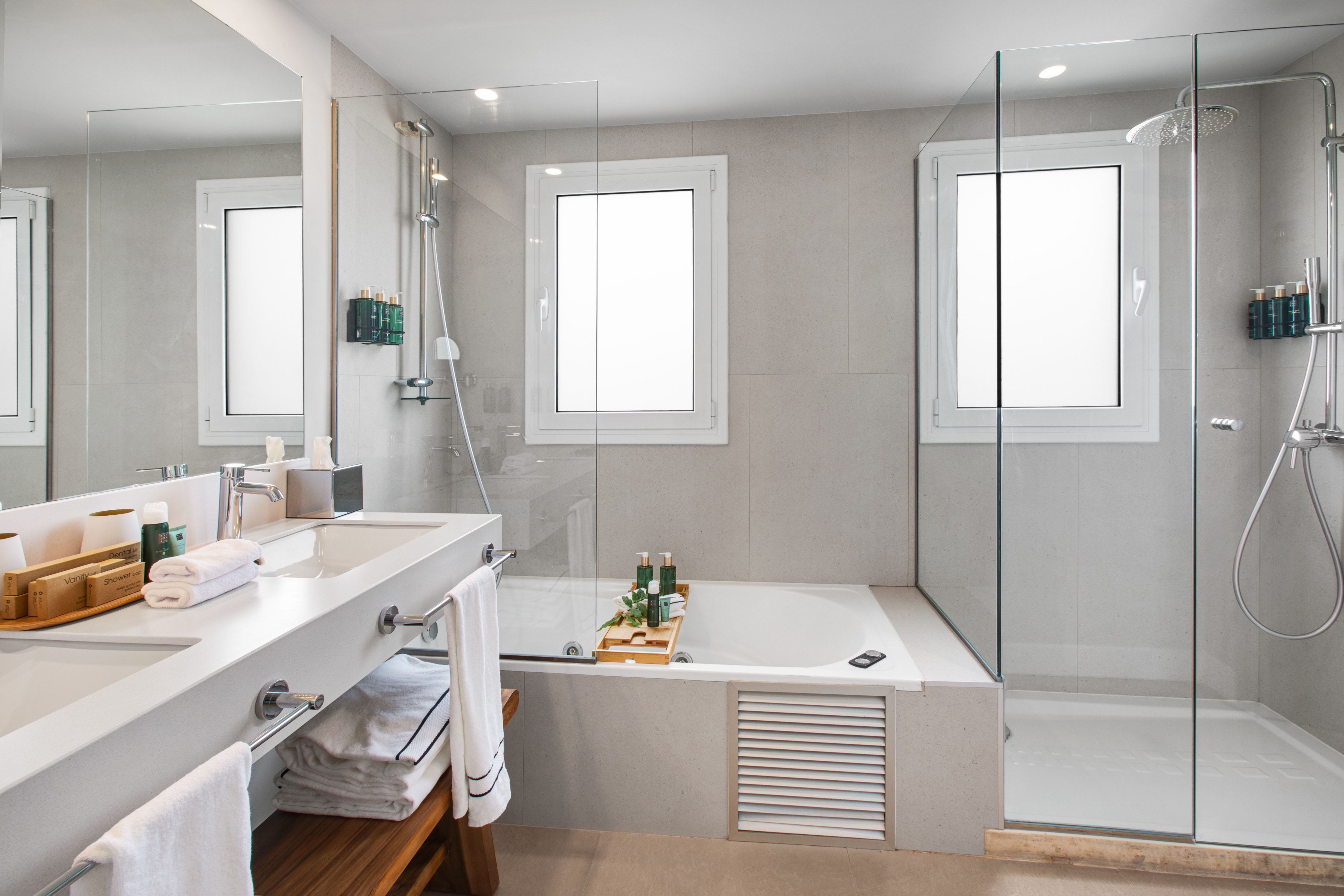 Bright modern bathroom with double vanity, bathtub, and walk-in shower.