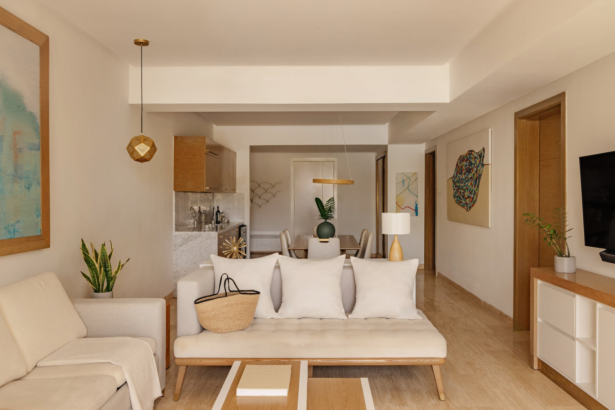 Open-concept living and dining room with neutral modern decor, cream sofa.
