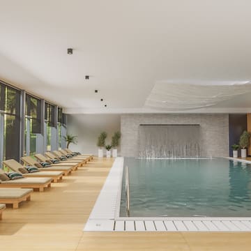 a pool with lounge chairs and a waterfall